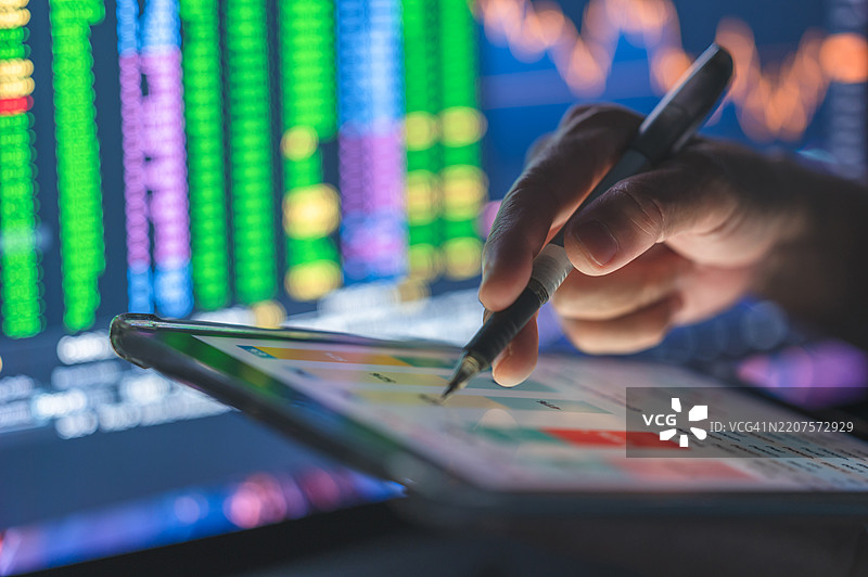 一位商务专业人士正在使用平板电脑，展示一个由人工智能驱动的智能交易界面，界面上有详细的图表和图形，以便做出明智的交易决策。图片素材