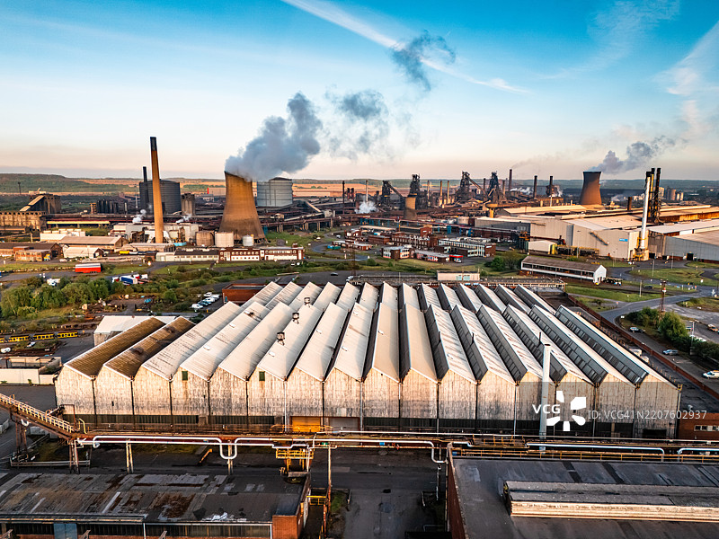 英格兰斯肯索普的钢铁厂综合体，日出时冒烟的烟囱图片素材