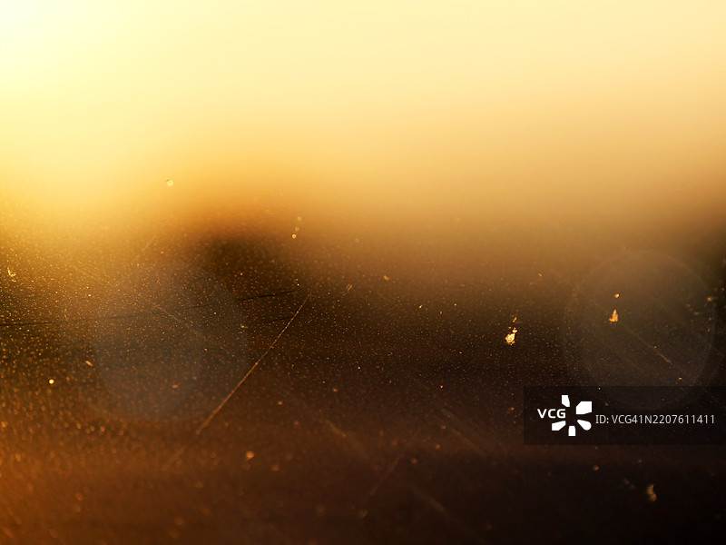 聚焦于一扇不透明、肮脏的窗户，背后是阳光照射和阴影。自然色彩。法国巴黎。图片素材