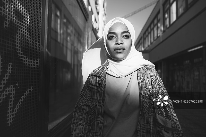 身穿头巾的年轻女性在柏林克罗伊茨贝格户外散步图片素材