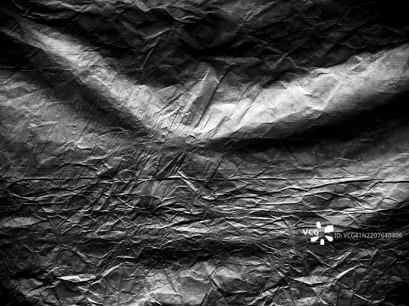 一张揉皱的牛皮纸，呈灰色和黑色调。粗糙的纹理。阳光与阴影。法国巴黎。全画幅 4:3图片素材