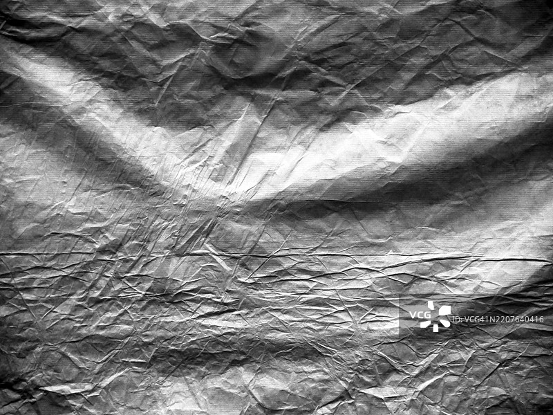 深灰色的皱纹牛皮纸特写。粗糙的纹理。阳光与阴影。法国巴黎。图片素材