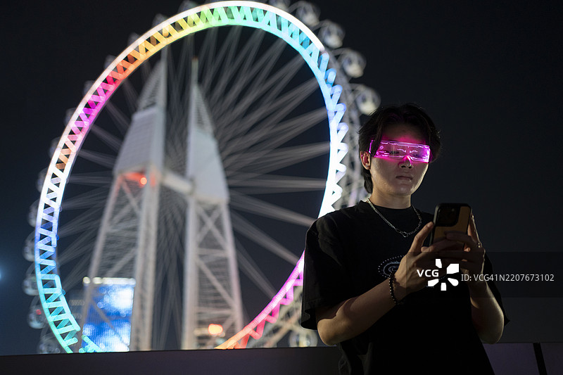 帅气的女孩体验发光眼镜的虚拟沟通概念图片素材