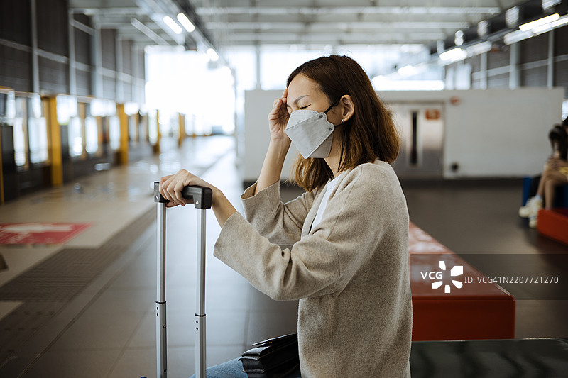 戴着防护口罩的亚洲女性在公共车站。图片素材