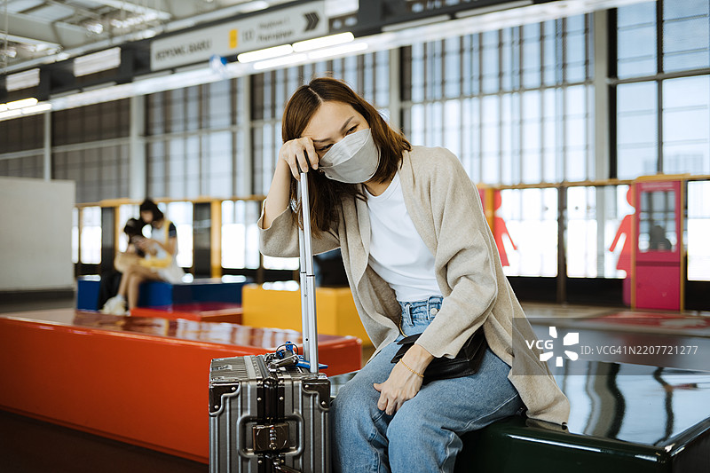 戴着防护口罩的亚洲女性在公共车站。图片素材