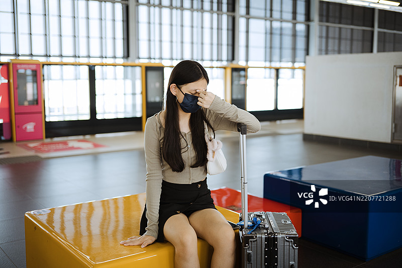 Asian young woman with protective mask in public station.图片素材