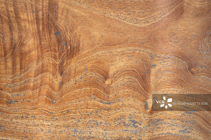 带有纹理图案的木质表面。木材的纹理清晰可见，颜色为棕色。图片素材