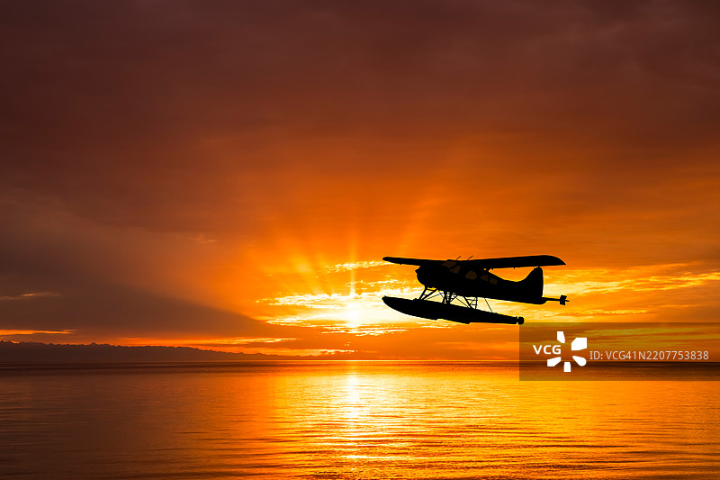 日落时分海面上的水上飞机剪影图片素材