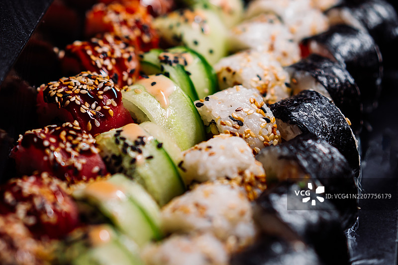 新鲜食材和色彩缤纷装饰的各式寿司卷图片素材