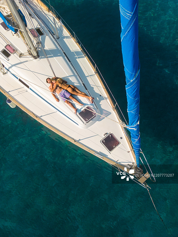 年轻情侣在帆船上享受假期图片素材
