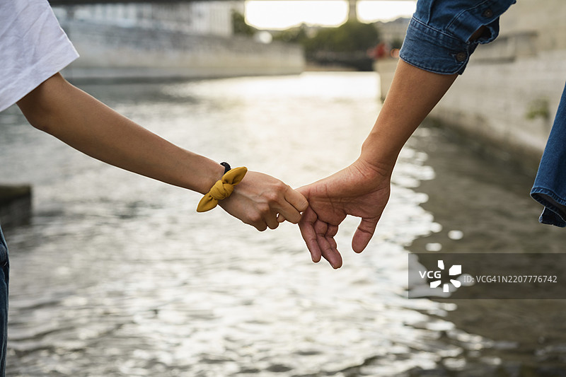 法国，巴黎，情侣在塞纳河边牵手的特写镜头图片素材