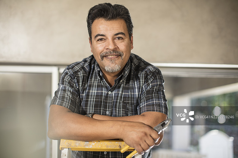 微笑男子在梯子上的肖像图片素材