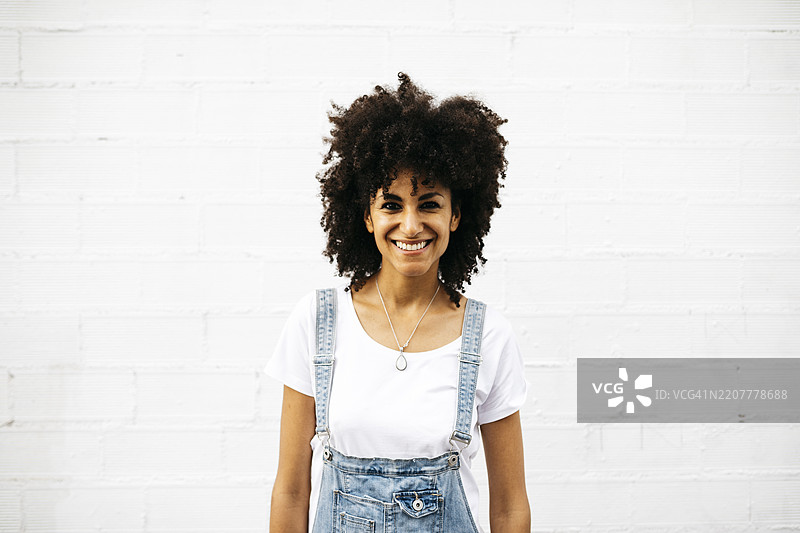 在白色墙壁前微笑的女性肖像图片素材