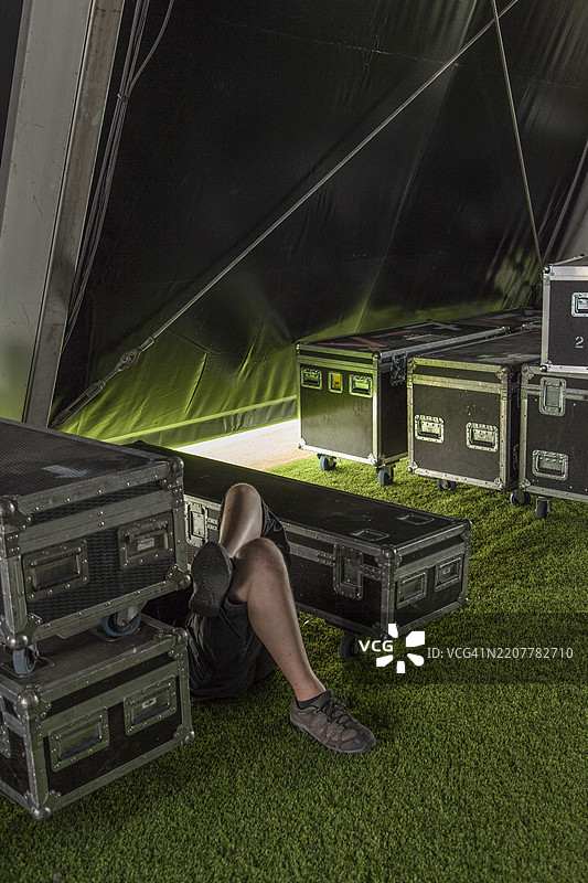 男子在后台的箱子之间休息图片素材