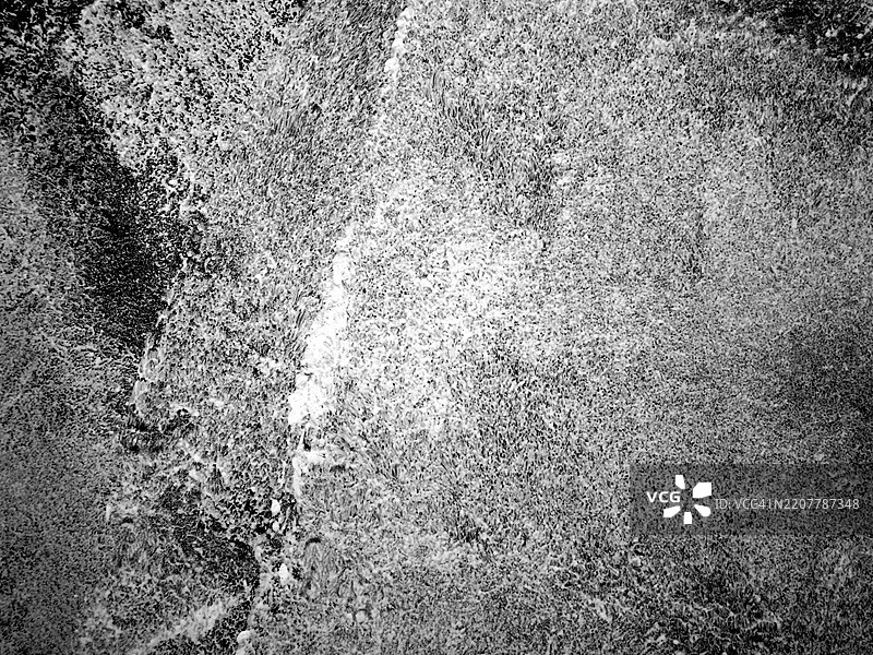 巴黎一面黑色墙壁上的白色和灰色油漆层。粗糙的纹理。图片素材