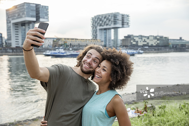 德国，科隆，幸福的情侣在河边自拍图片素材