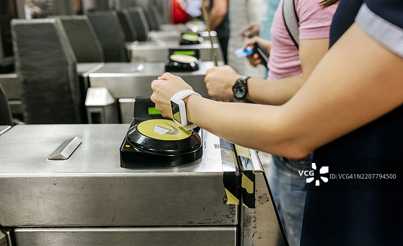 年轻女性在地铁上用智能手表付款，部分视角图片素材