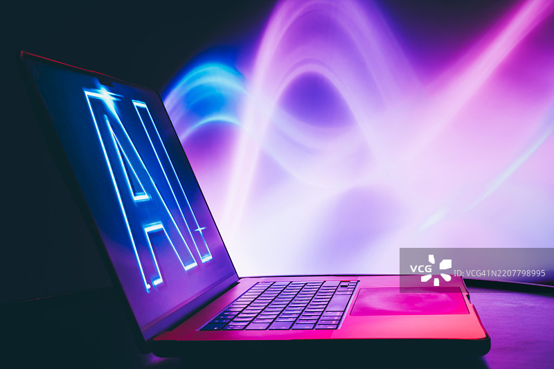 带有人工智能屏幕的笔记本电脑，霓虹灯下。图片素材