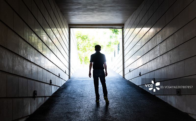 男人走向隧道尽头的光亮图片素材