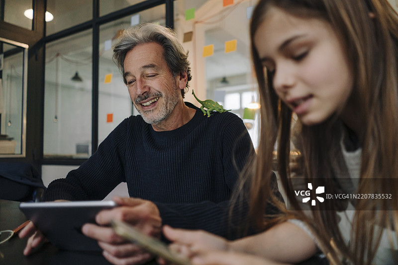 休闲的高级商务人士和女孩在办公室使用平板电脑和智能手机图片素材