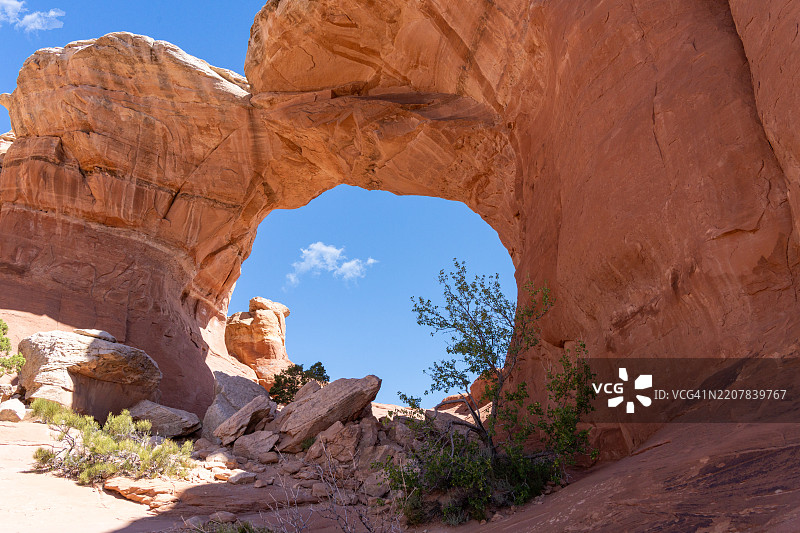透过拱门自然石拱望向阿奇斯国家公园上方的晴朗天空图片素材