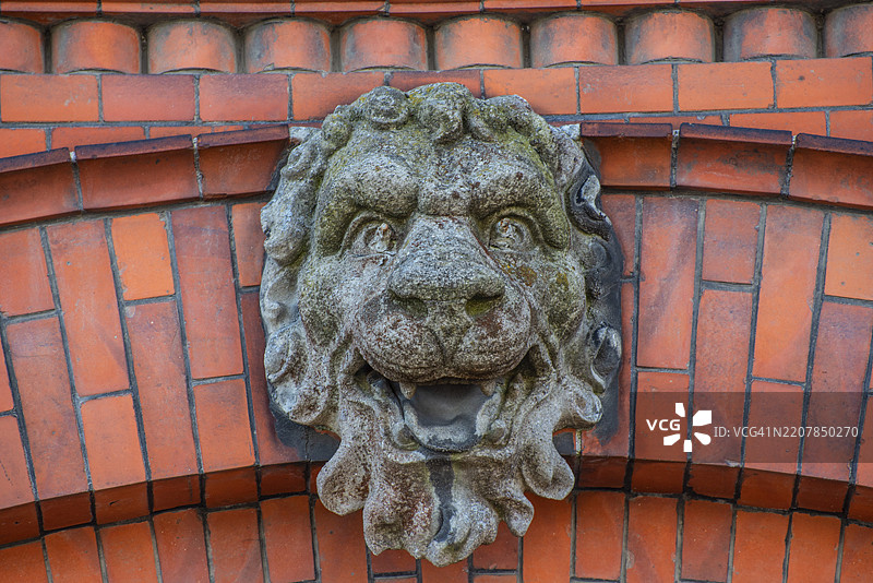 瑞典斯科纳县伊斯塔德装饰砖墙上的混凝土狮子头图片素材