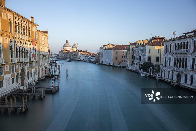 黄昏的光线,从学院桥俯瞰大运河,背景是圣玛丽亚·德拉·萨卢特大教堂,长时间曝光,意大利威尼斯,欧洲图片素材