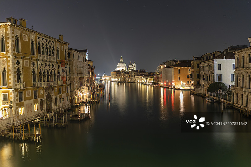 从学院桥俯瞰大运河,背景是圣玛丽亚·德拉·萨卢特大教堂,夜景,长时间曝光,意大利威尼斯,欧洲图片素材
