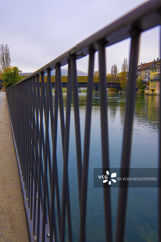 秋天的瑞士索洛图恩州奥尔滕，阿尔河上的历史木桥（Holzbrücke）及其步道和栏杆图片素材