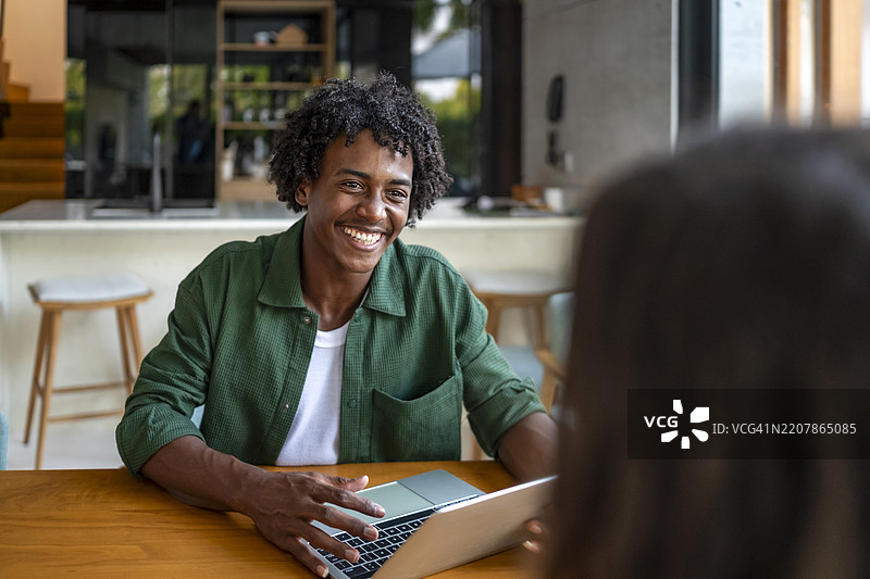 微笑的男士在现代办公室中进行友好的交谈图片素材