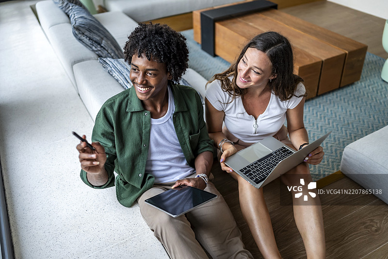 快乐的同事们在用笔记本电脑和平板电脑合作项目图片素材