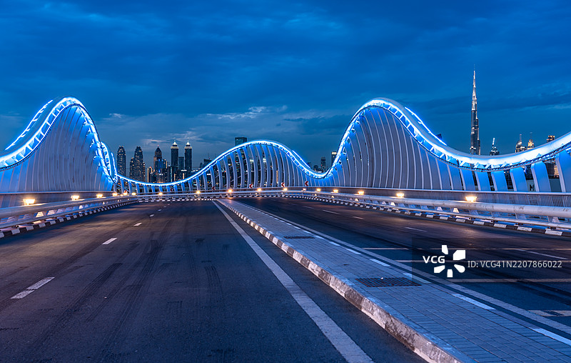 波浪形发光桥与迪拜天际线图片素材