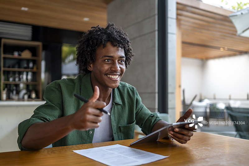 微笑的专业人士在家中办公室视频通话时竖起大拇指图片素材