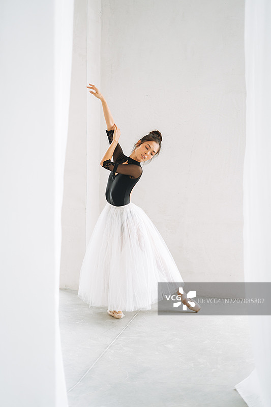 年轻美丽的日本芭蕾舞者穿着芭蕾裙在舞蹈教室中跳舞图片素材
