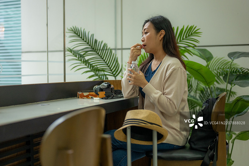 照顾自己：一位亚洲女性在现代客厅中的休息时刻图片素材