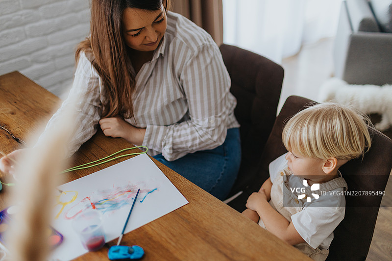 小男孩和妈妈一起用水彩画画，玩得很开心图片素材