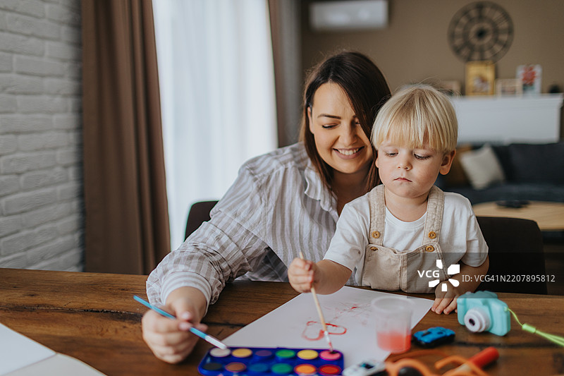 母亲和儿子在家用水彩画画图片素材