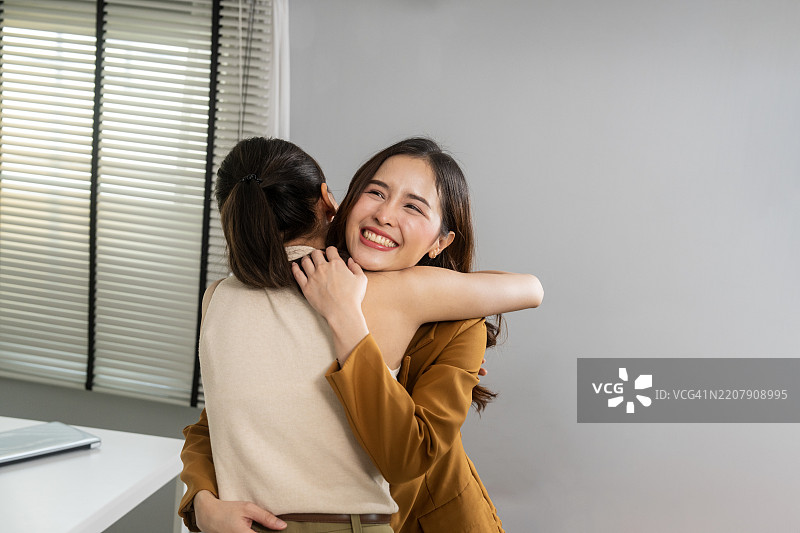 两个人在室内温暖友好地拥抱图片素材