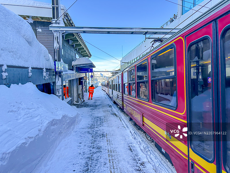 在阳光明媚的冬日，克莱因·谢德格的火车站和少女峰铁路列车图片素材