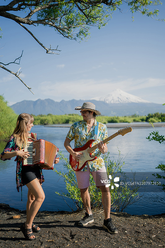 音乐家在河边演奏手风琴和吉他图片素材