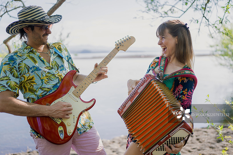 湖边的音乐家演奏手风琴和电吉他图片素材