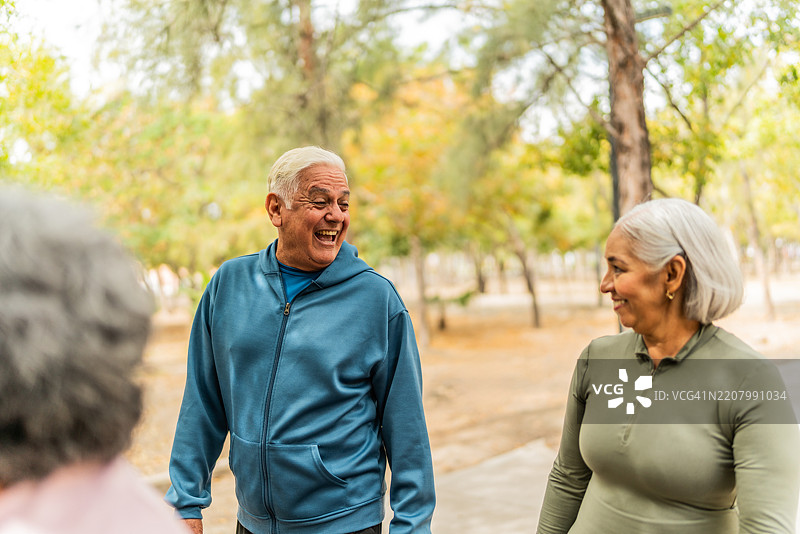 老年朋友在公园里交谈散步图片素材