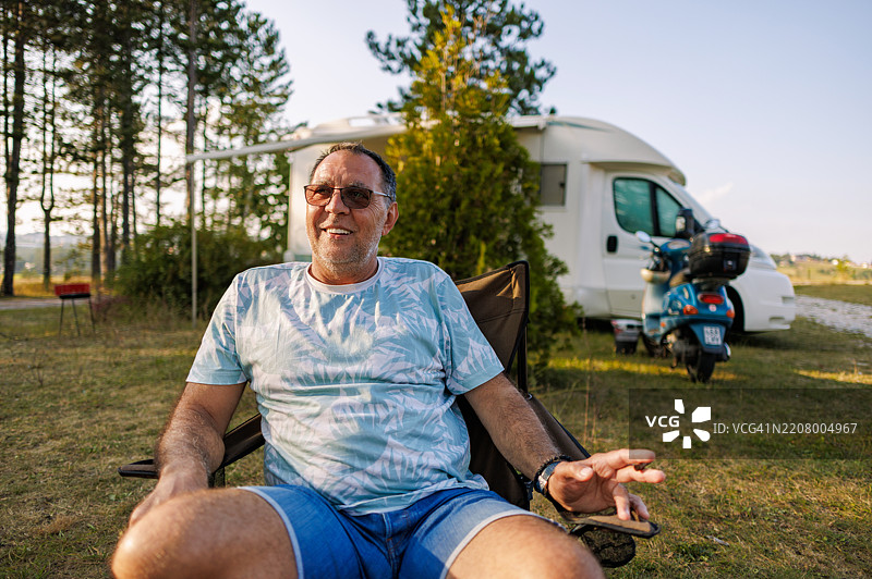 成熟男子坐在房车前抽烟图片素材