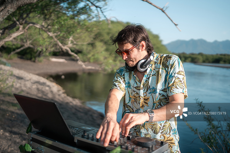 在热带湖边派对上播放音乐的DJ图片素材