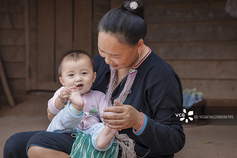 老挝北部村庄里抱着宝宝的老挝妈妈图片素材