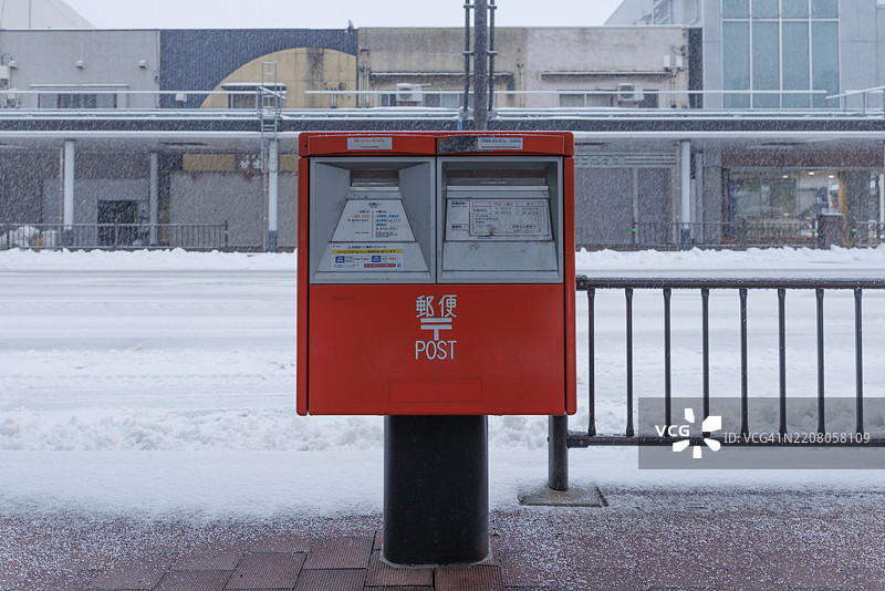 冬季早晨，鸟取市主干道上的邮箱，正值大雪纷飞。图片素材