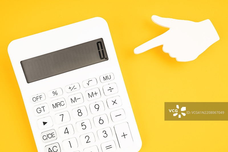 白色计算器与黄色背景上的手指形状便签纸。图片素材