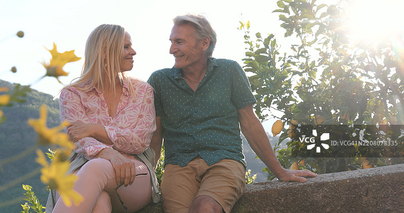 成熟夫妇坐在果园上方的墙上图片素材