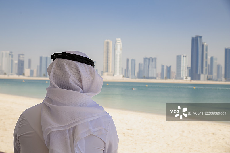 商人从海滩上眺望城市图片素材