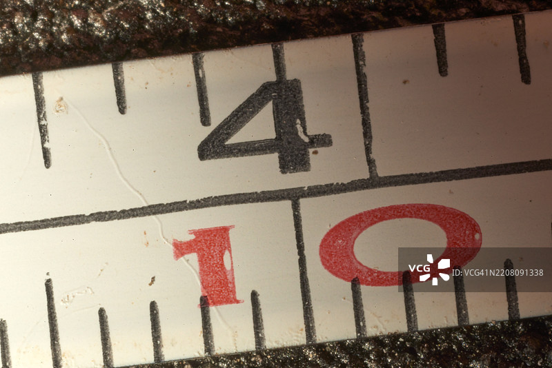 特写的卷尺聚焦在四英寸标记上,显示出精确的十分之一英寸测量,突显了尺寸评估中的技术准确性。图片素材